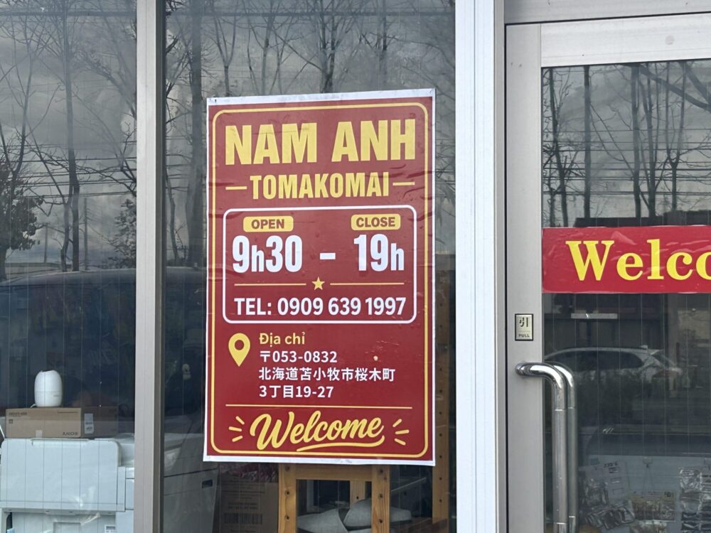 NAM ANH MARTの入口に掲示された営業時間と桜木町の住所