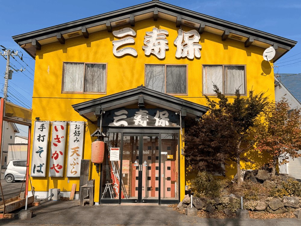 苫小牧市豊川町の和食処「三寿保」の外観。黄色い外壁と大きな看板
