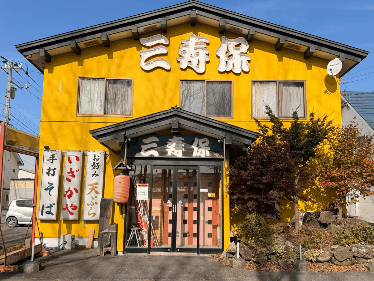 苫小牧市豊川町の和食処「三寿保」の外観。黄色い外壁と大きな看板
